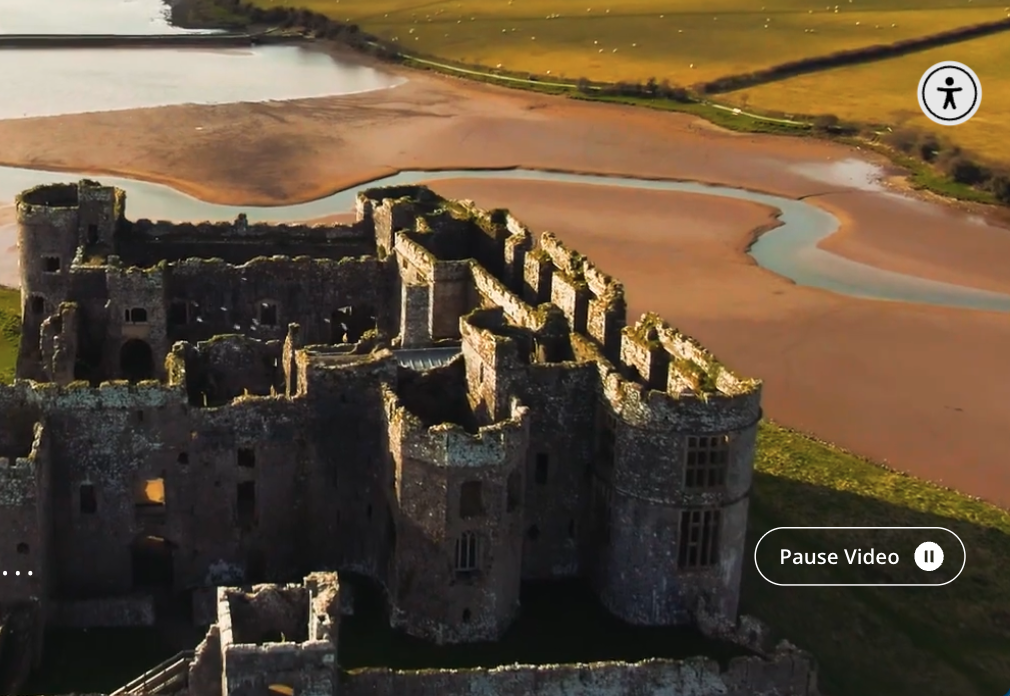 Video still with a clearly marked “Pause Video” button. The video shows a castle by a river.